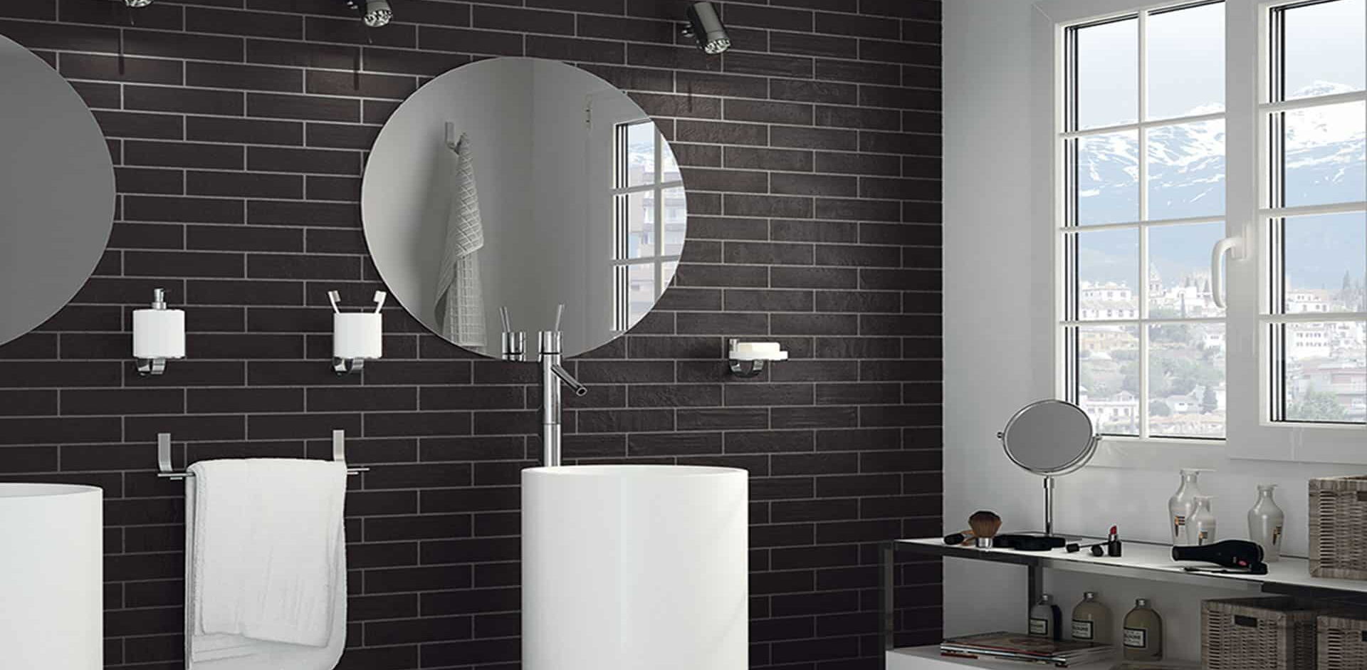 Modernes Badezimmer mit schwarzen Wandfliesen und weißen Badmöbeln