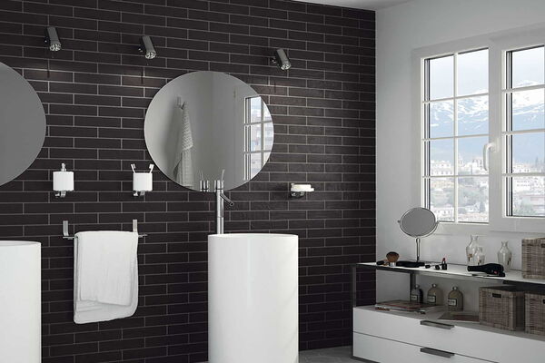 Modernes Badezimmer mit schwarzen Wandfliesen und weißen Badmöbeln