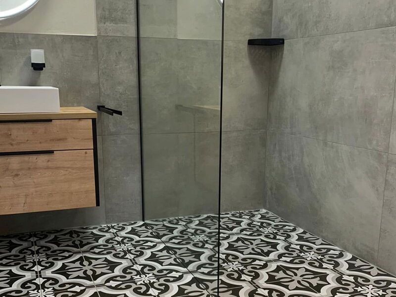 Badezimmer mit Ornamentbodenfliesen und offener Dusche