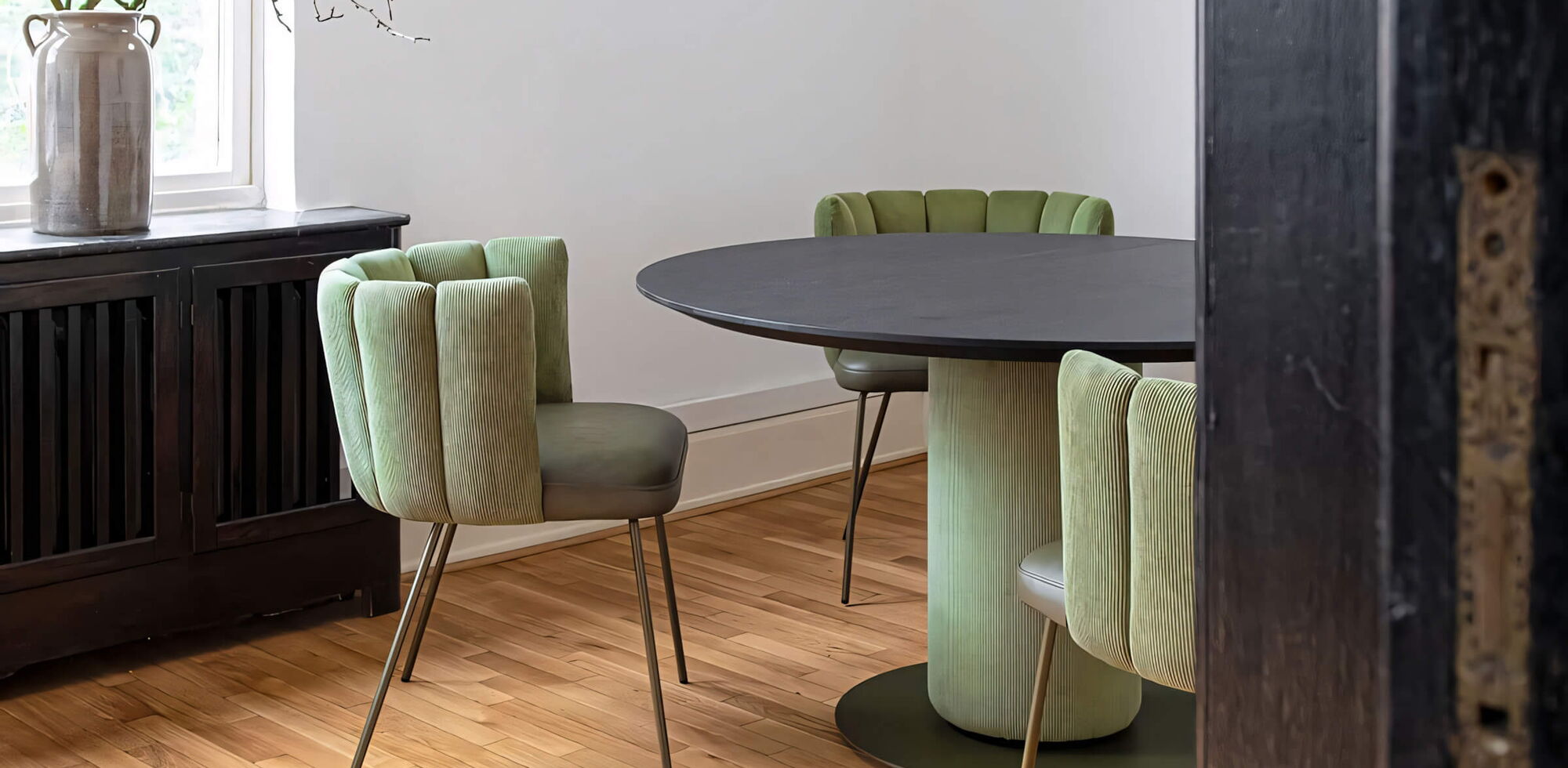 Esstisch mit grünen Polsterstühlen