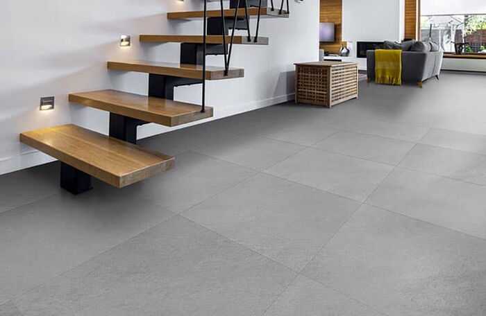 Großformatige Fliesen unter einer offenen Holztreppe