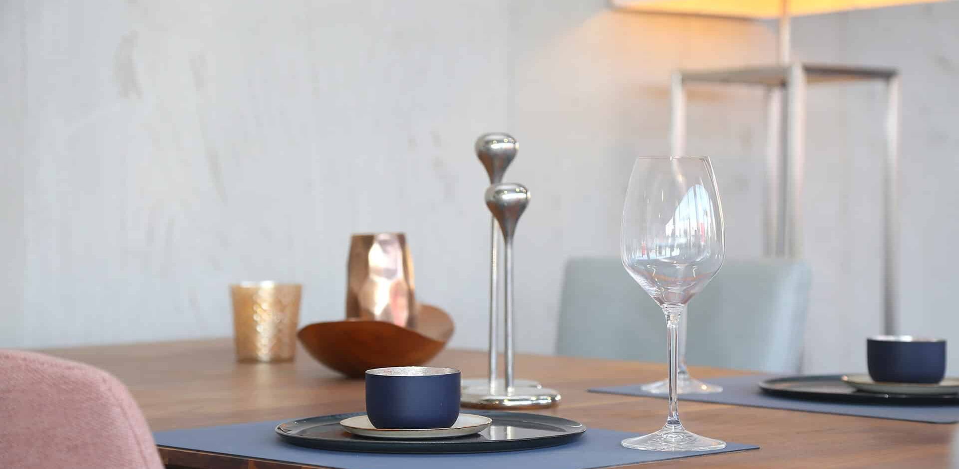 Detailaufnahme eines hochwertigen Esstischs, auf dem Dekoartikel stehen