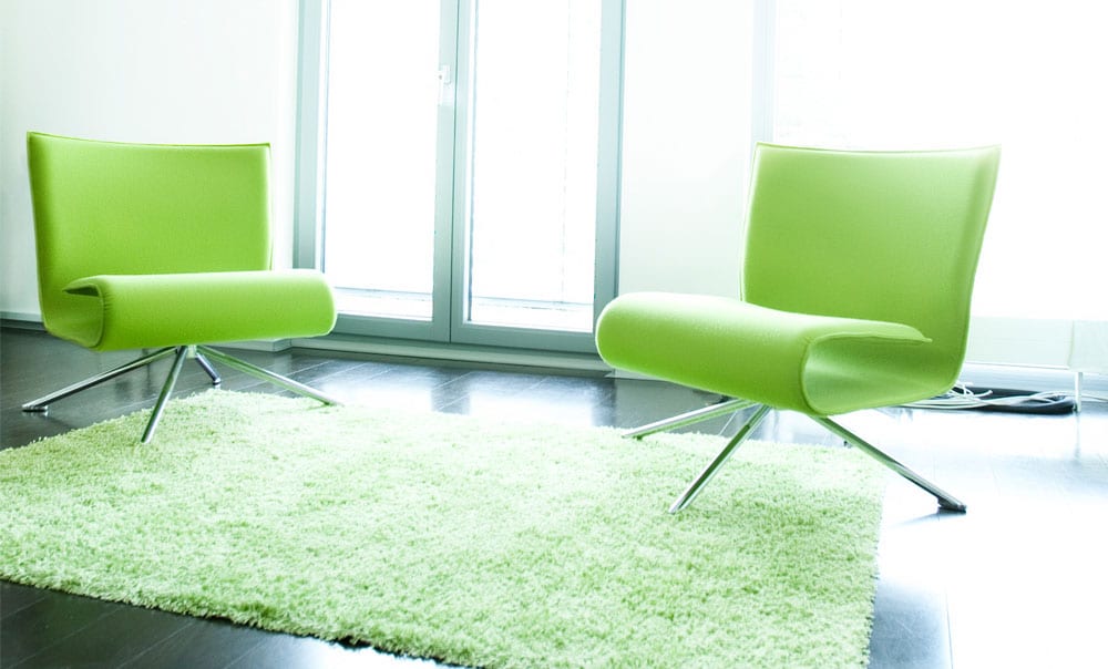 Zwei grüne Sessel auf grünem Teppich