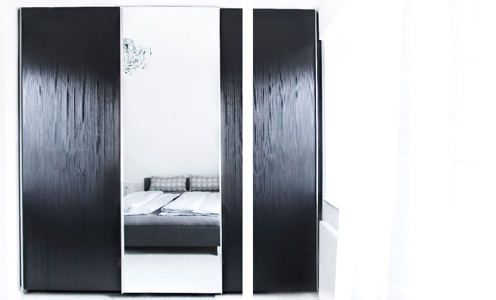 Kleiderschrank mit Spiegel, indem man ein Bett sieht